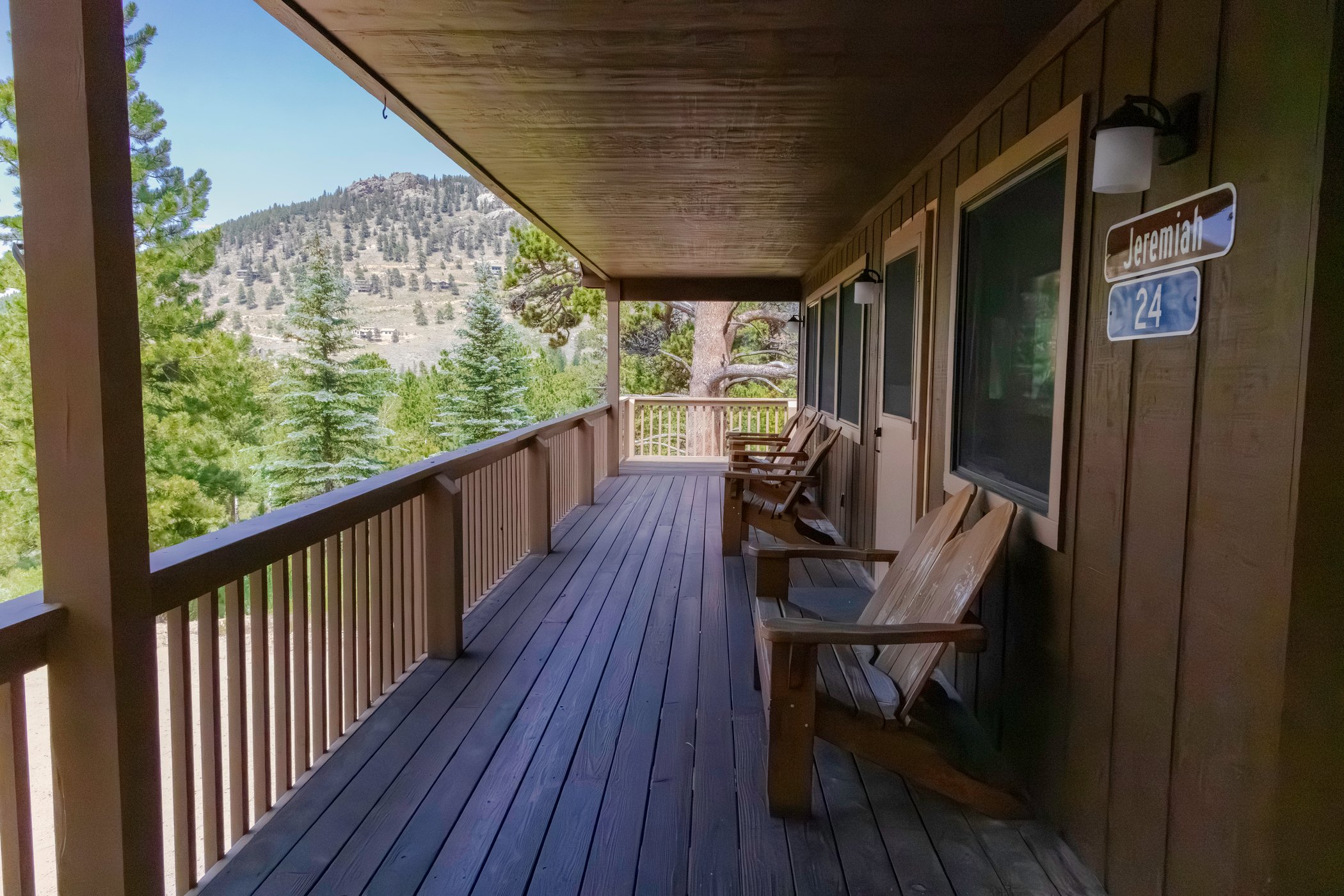 Shaded cabin porch overlooking the YMCA grounds and nearby mountains