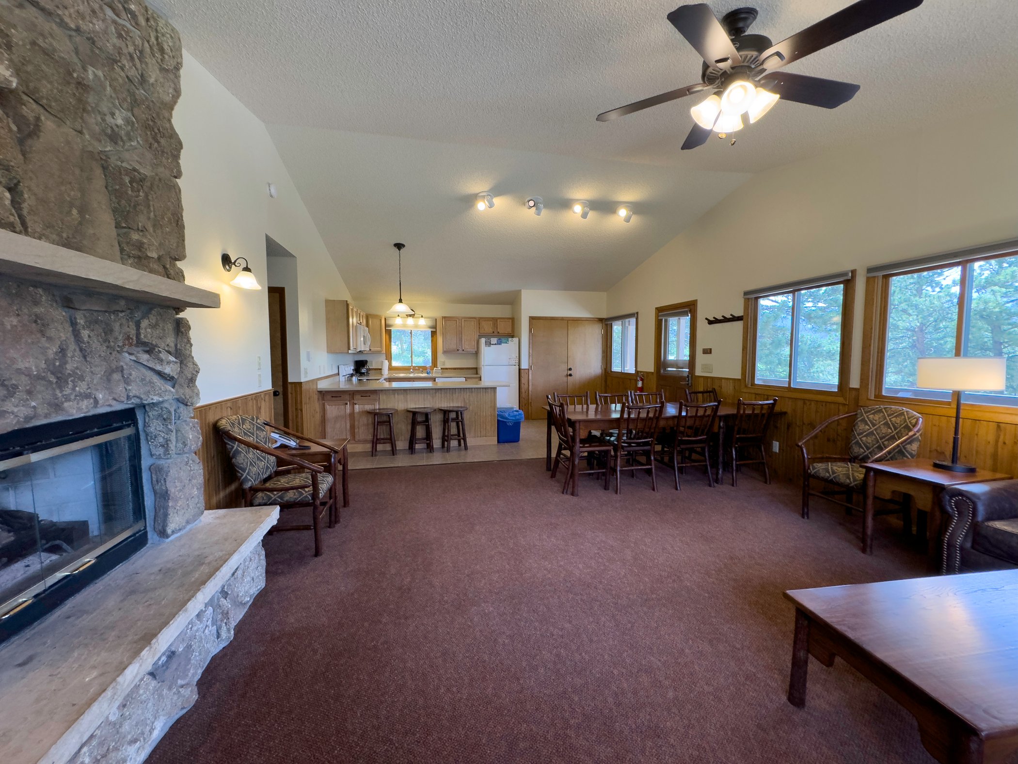 Cabin interior. Kitchen, main entry, and living room with fireplace.